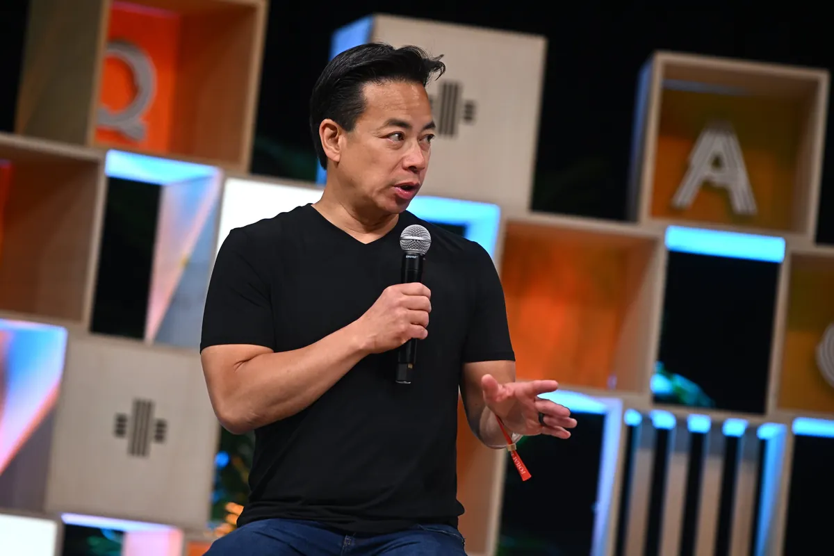 Ken Sim holds a microphone while answering questions at Collision 2023.